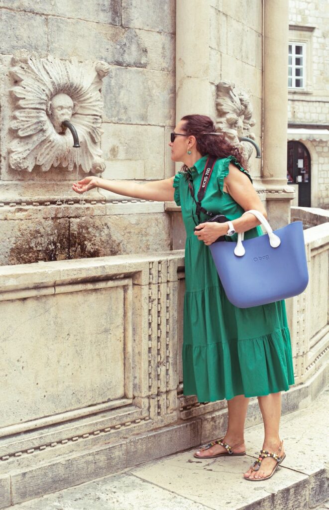 a woman washing her hand from a fountain