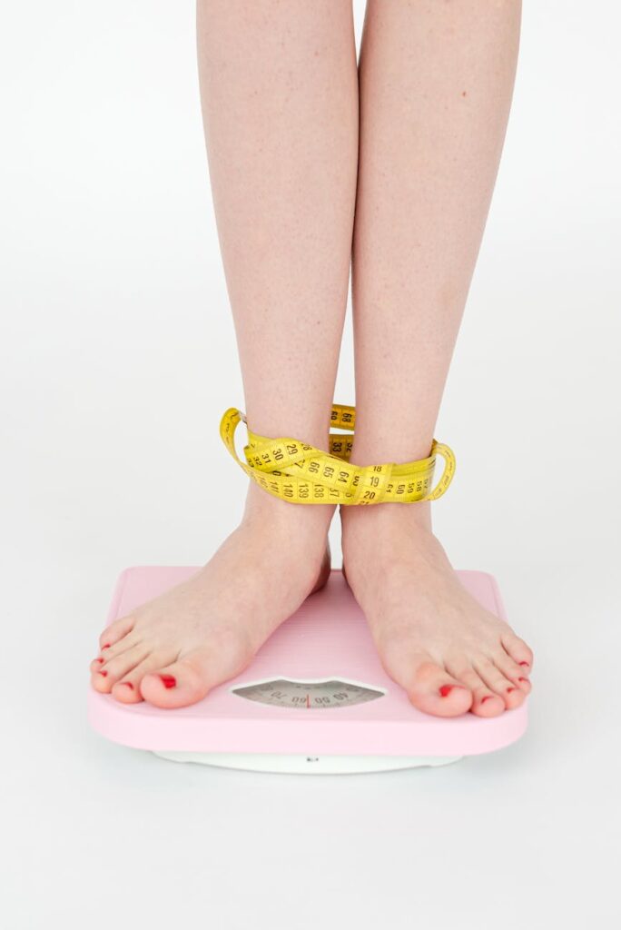 woman tied with measuring tape standing on scales